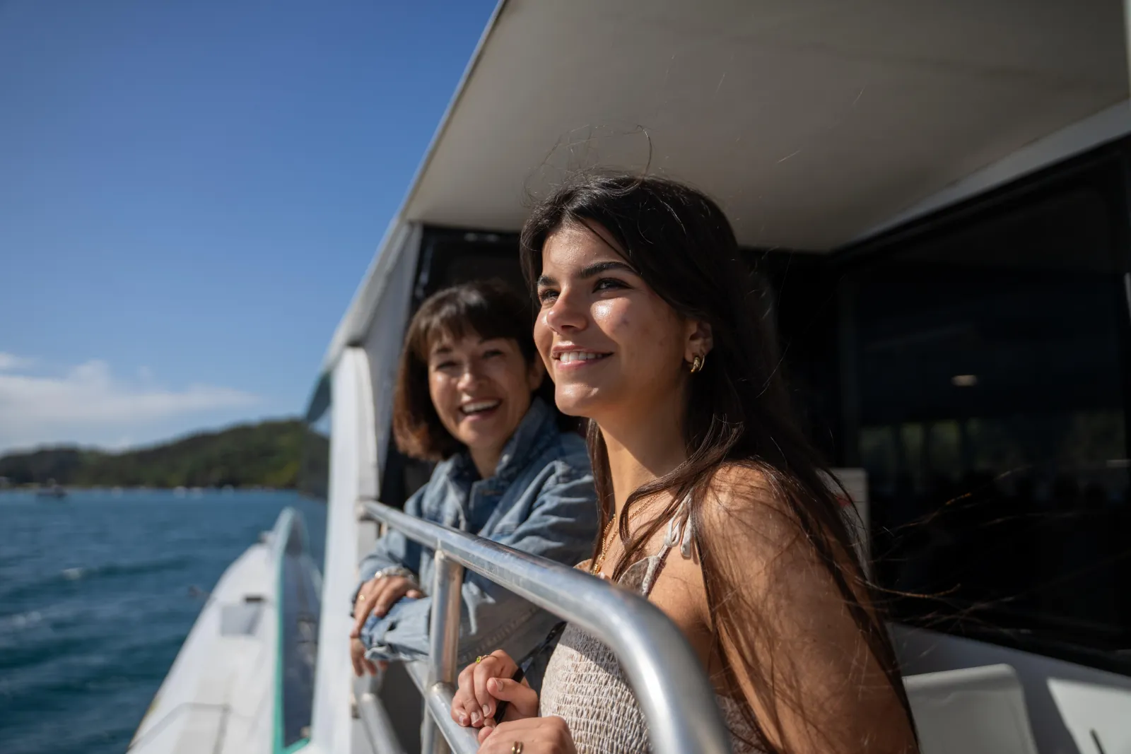 Two women at the ferry rail looking out over the Hauraki Gulf