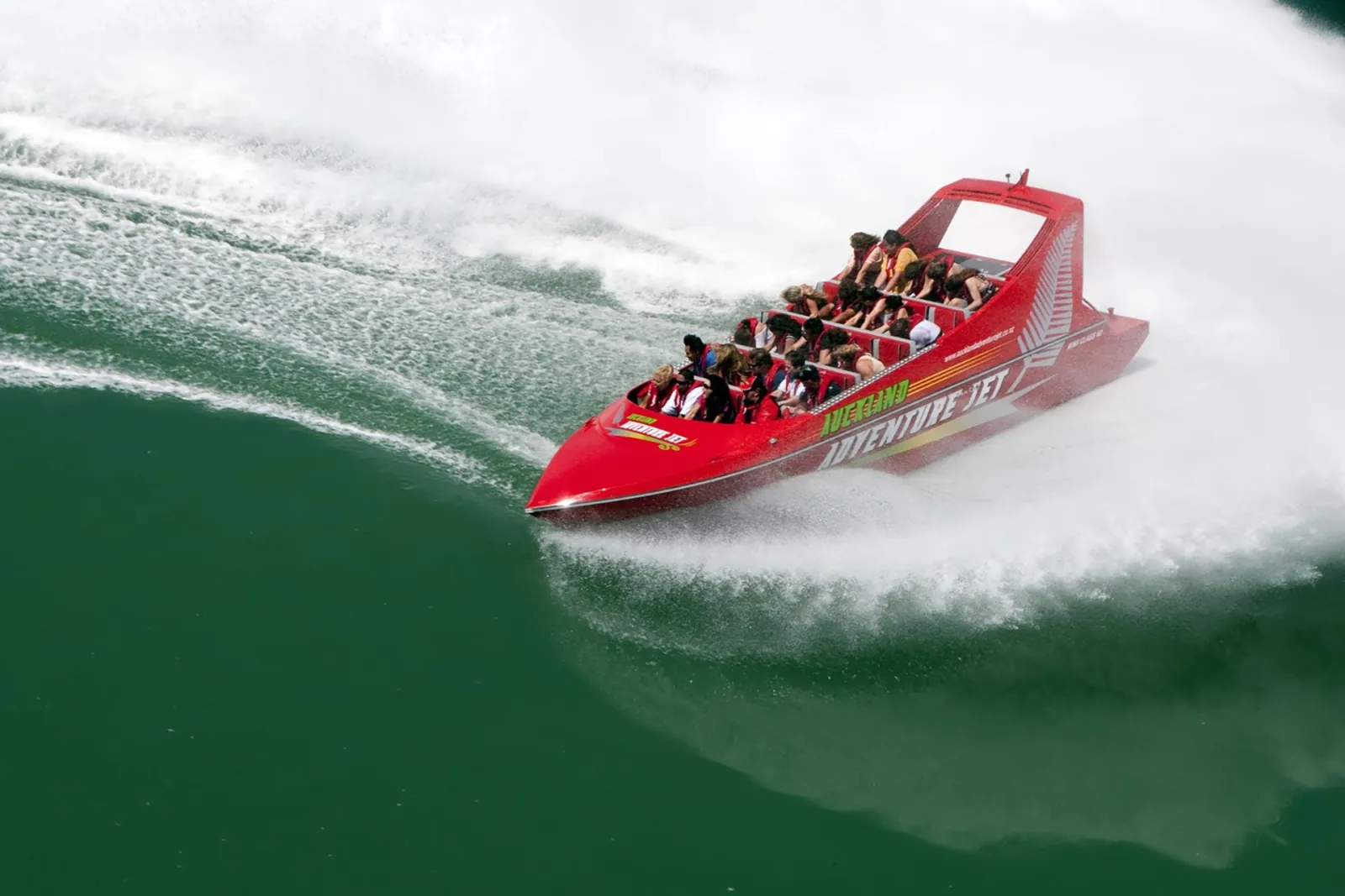 Aerial view of the full jet boat spinning on green water
