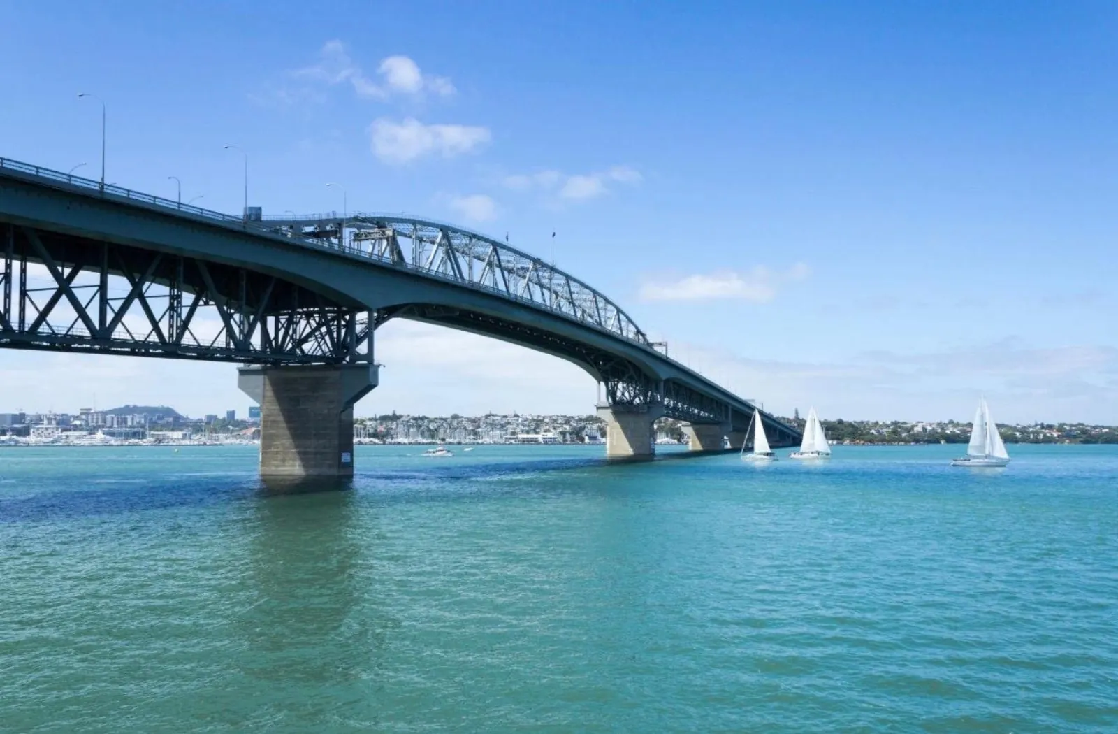 Auckland Harbour Bridge and small yachts under a clear midday sky