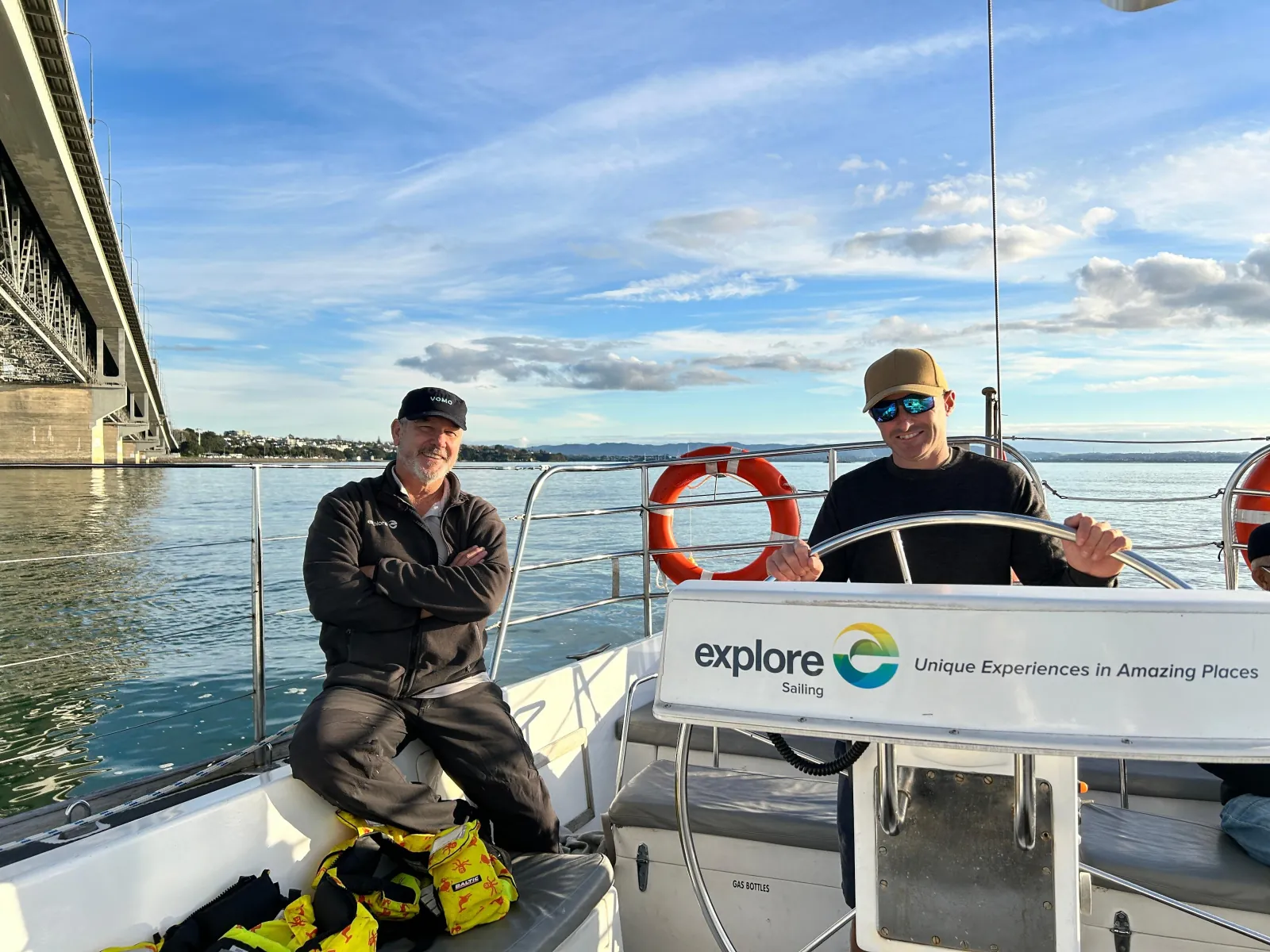 Guest steering at the yacht's wheel near the Auckland Harbour Bridge