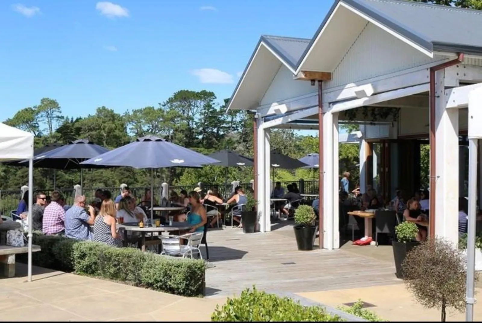 Covered outdoor terrace of The Riverhead tavern busy with diners under umbrellas