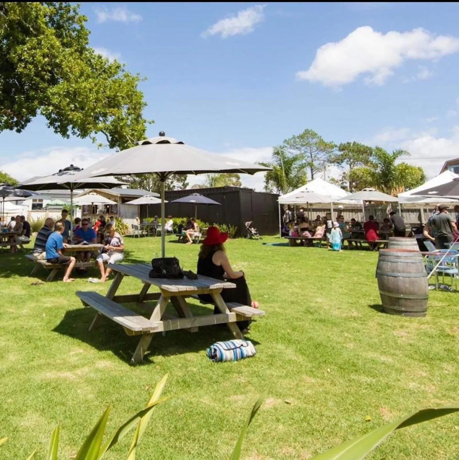 Picnic tables and umbrellas on The Riverhead's sunny lawn