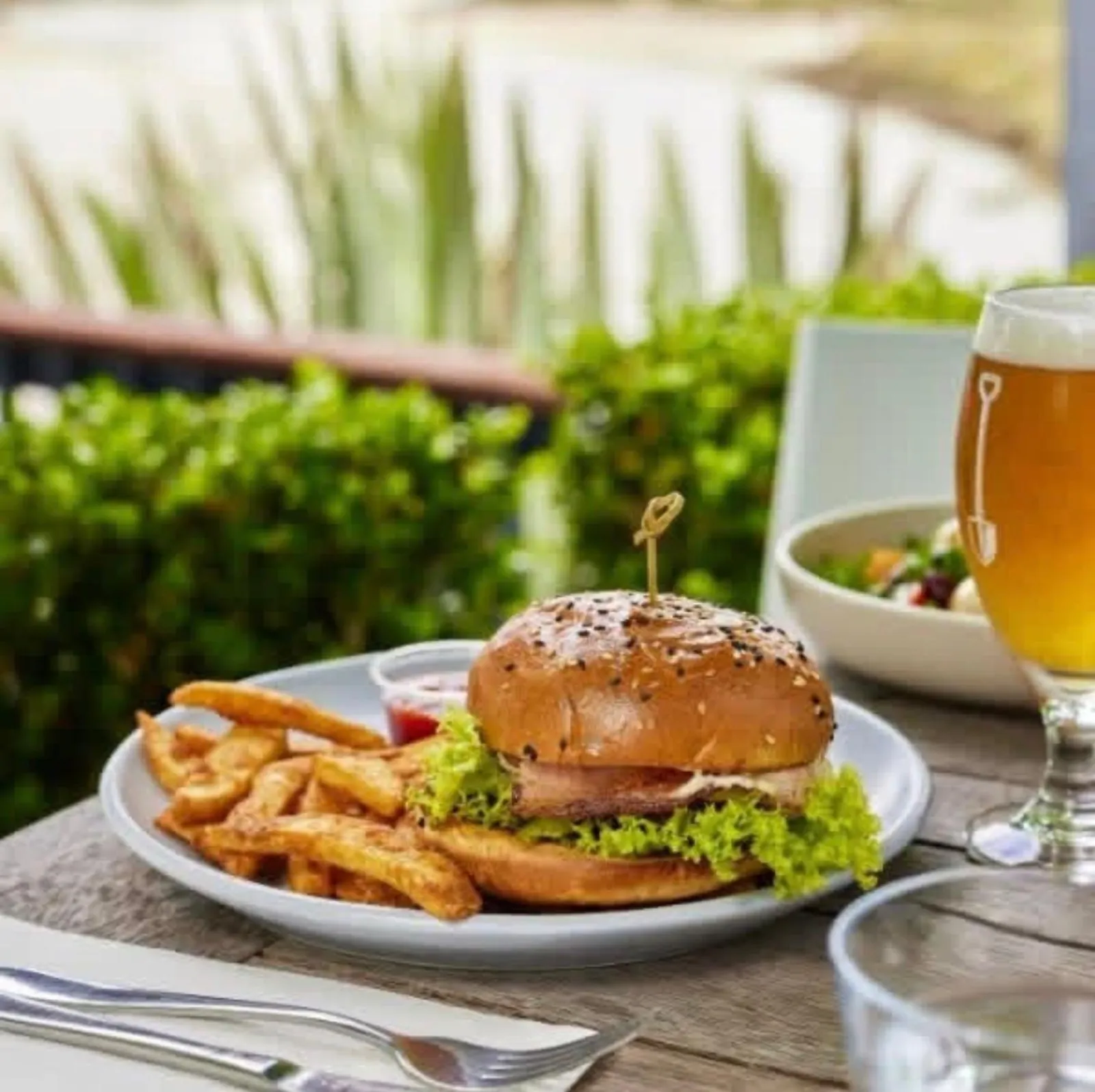 Burger, fries and a glass of beer on a table at the tavern