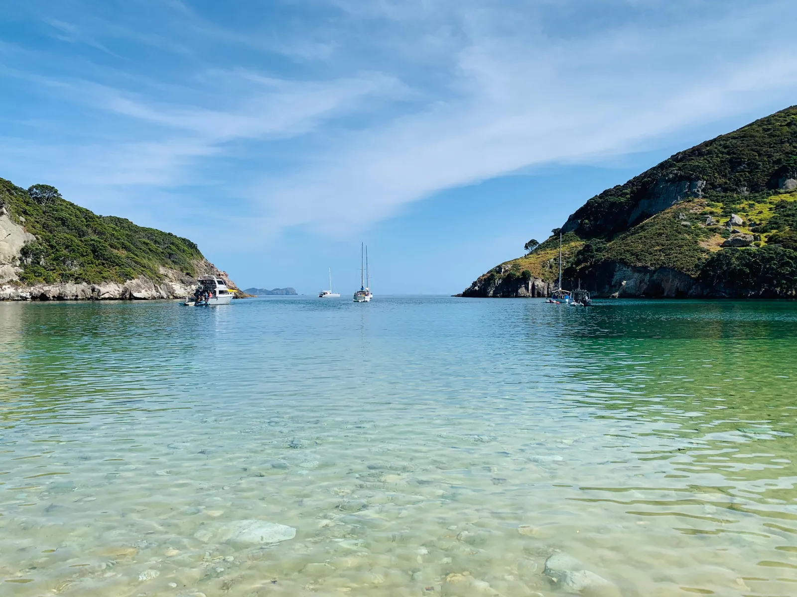 Clear shallow water in a quiet bay with yachts at anchor