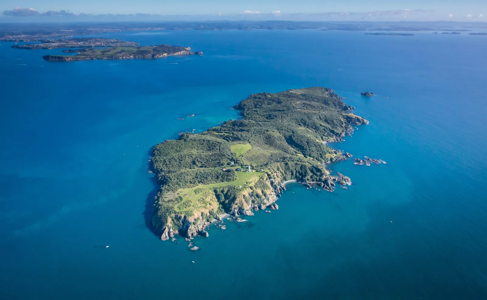 Aerial view of Tiritiri Matangi Island surrounded by deep blue sea