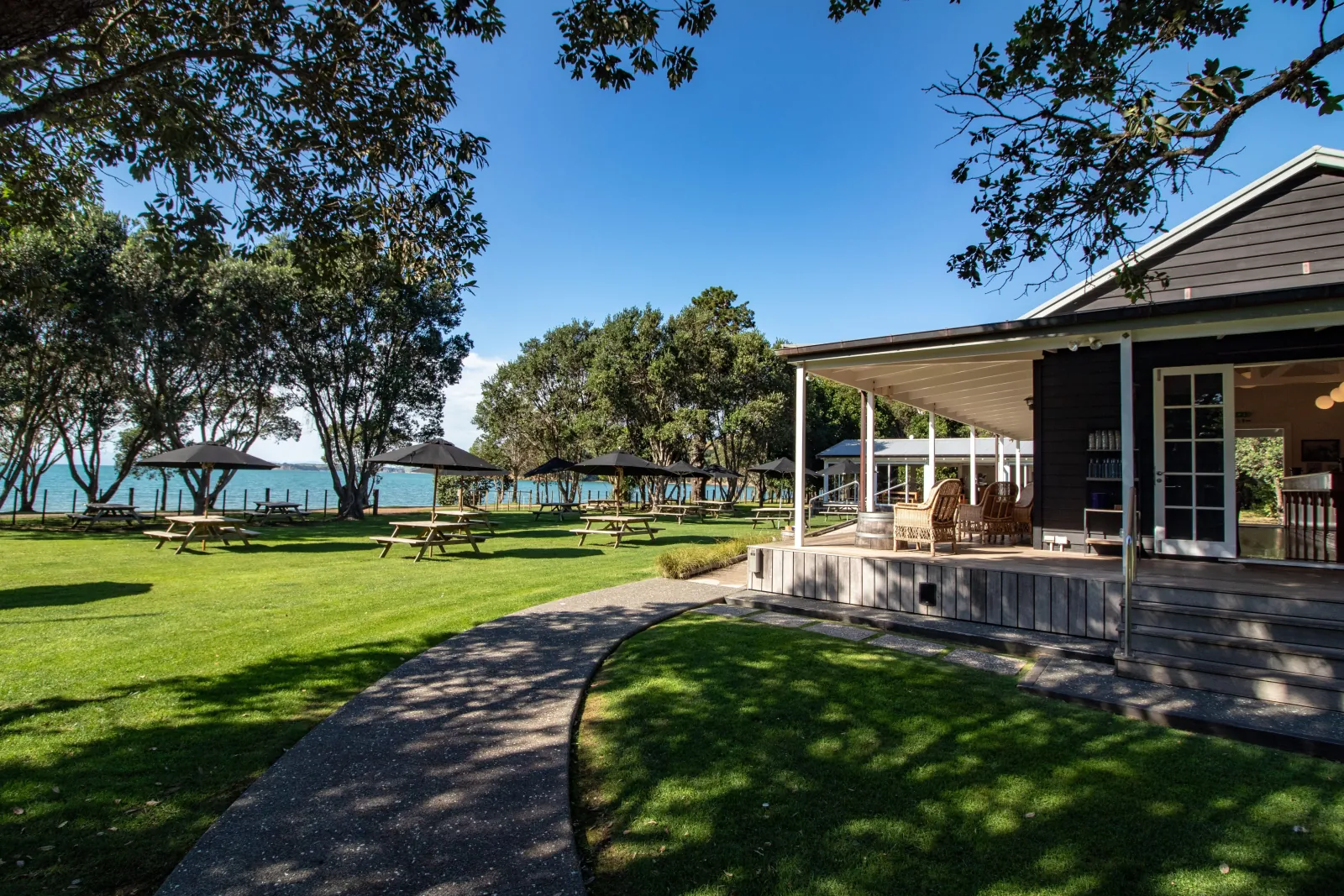 Man O' War Tasting Room with lawn and picnic tables under trees